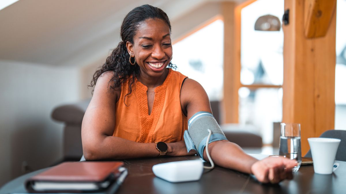 Woman measuring her blood pressure at home after taking a supplement