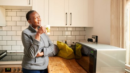 woman standing in the kitchen drinking coffee