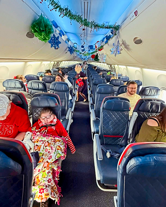 Little ones ride on a plane decked out in holiday decorations