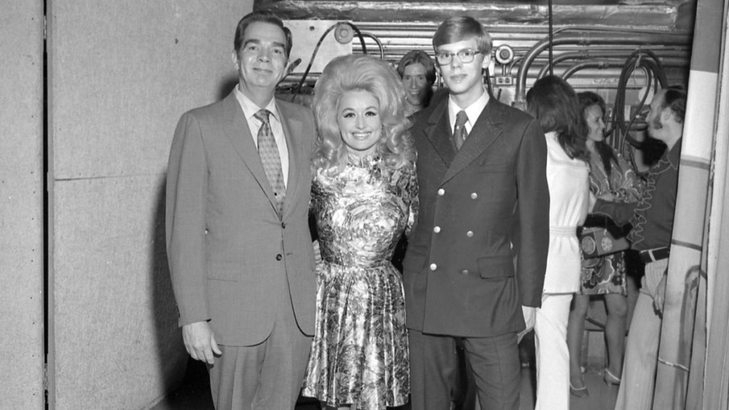 Dolly Parton poses for the camera with DJs backstage at the Grand Ole Opry circa 1970