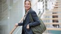 Middle-aged woman happily pauses, while climbing the steps of an office building, as if to say that she just got hired