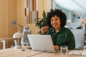 Smiling woman at her laptop enrolling in Medicare
