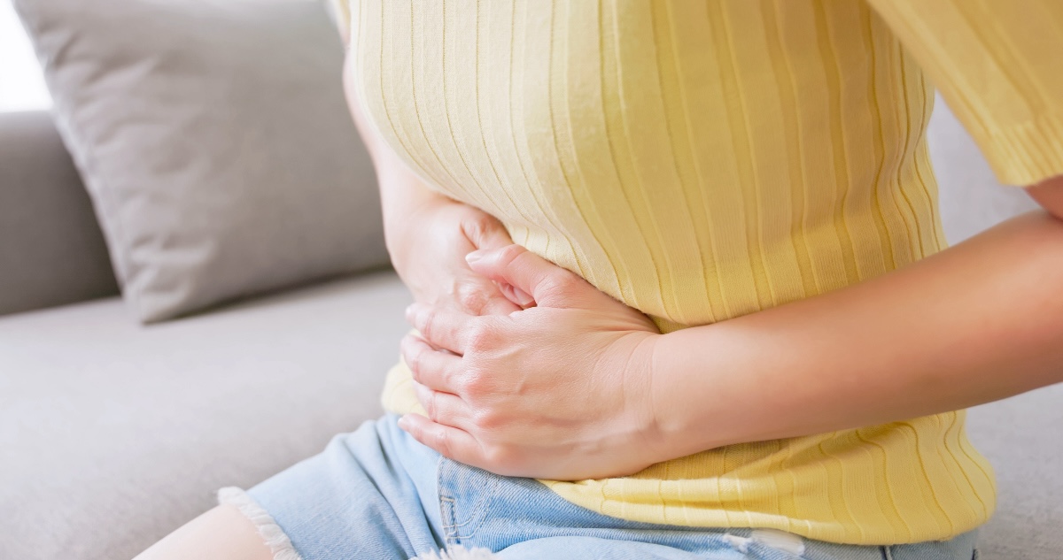 Close-up of a woman's hands on her stomach to try to soothe bloating