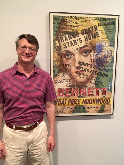 Dwight Cleveland poses with a poster for What Price Hollywood? (1932)