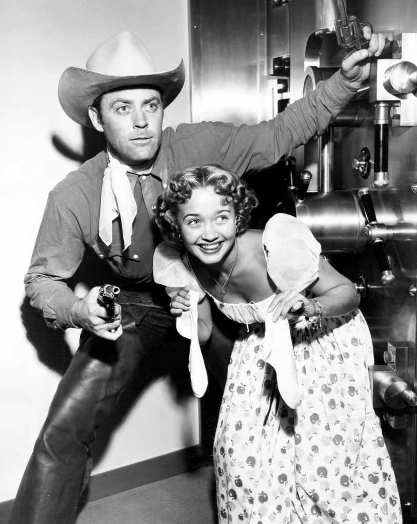 To mark the opening of a new Hollywood bank, Allan 'Rocky' Lane covers Jane Powell as she attempts to deposit her bobby socks, October 1948
