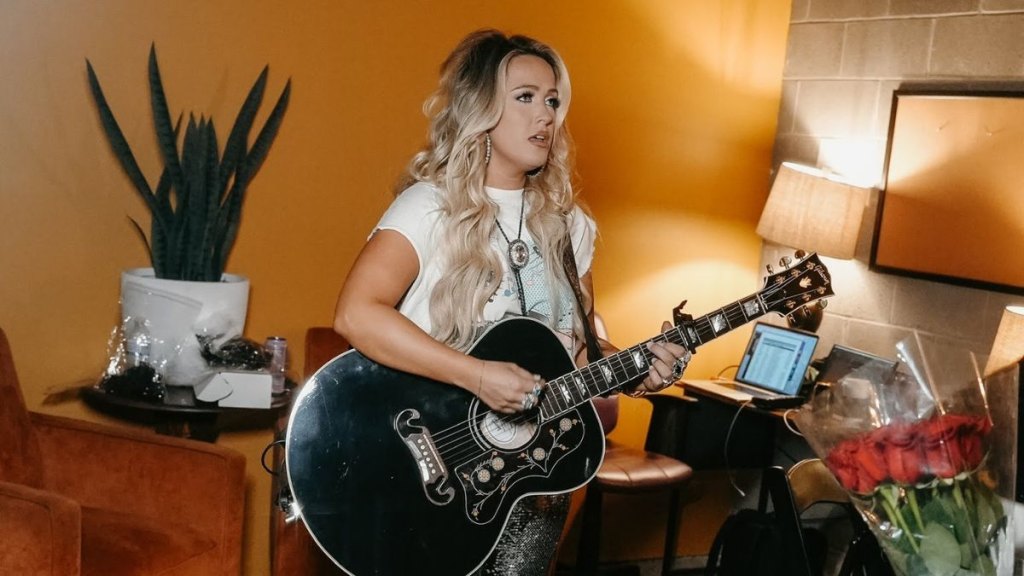 Priscilla Block strums her guitar backstage in a greenroom during her tour