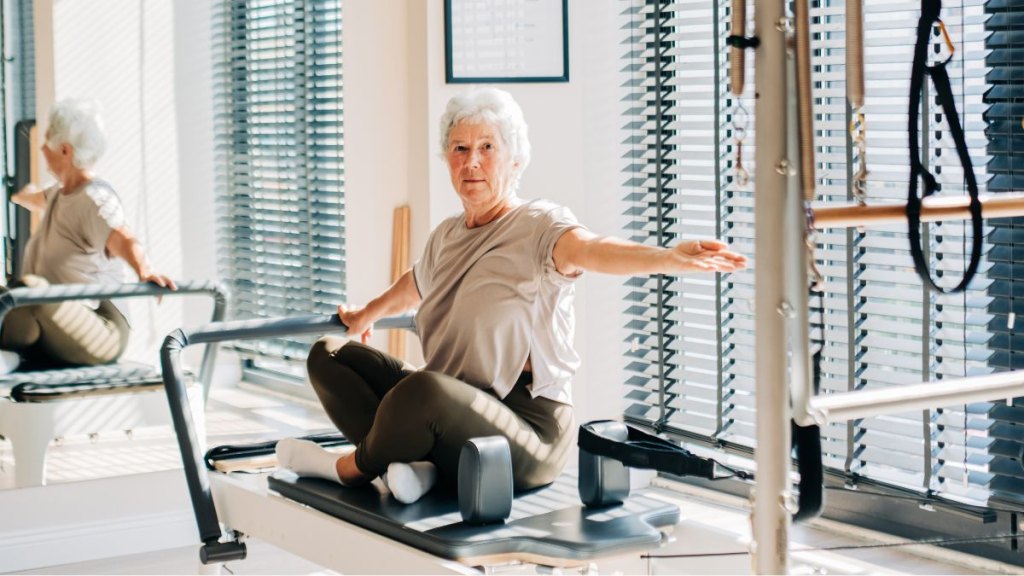 Senior woman doing exercises on a reformer during Pilates classes