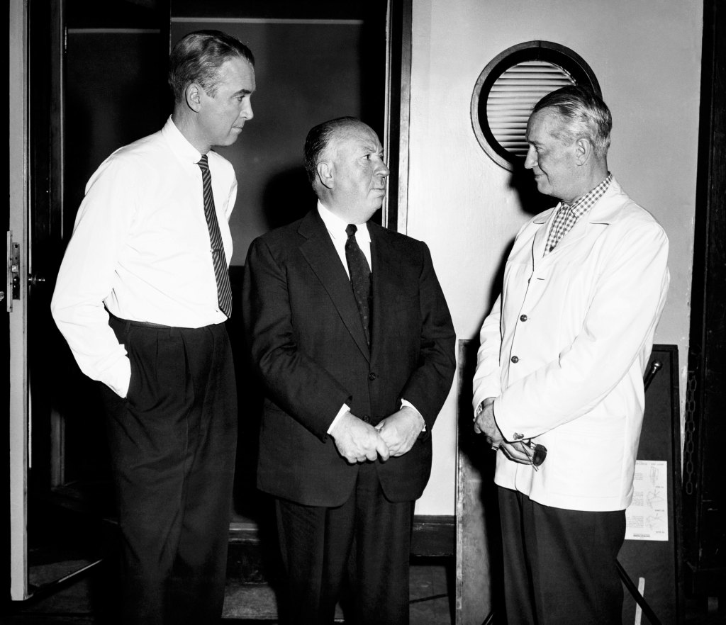 VERTIGO, from left: James Stewart and director Alfred Hitchcock with visitor Maurice Chevalier, on set