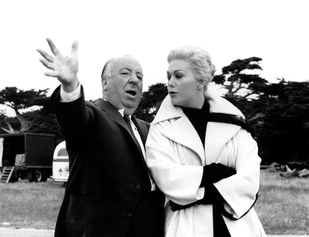 VERTIGO, Director Alfred Hitchcock hams it up on set with Kim Novak, 1958