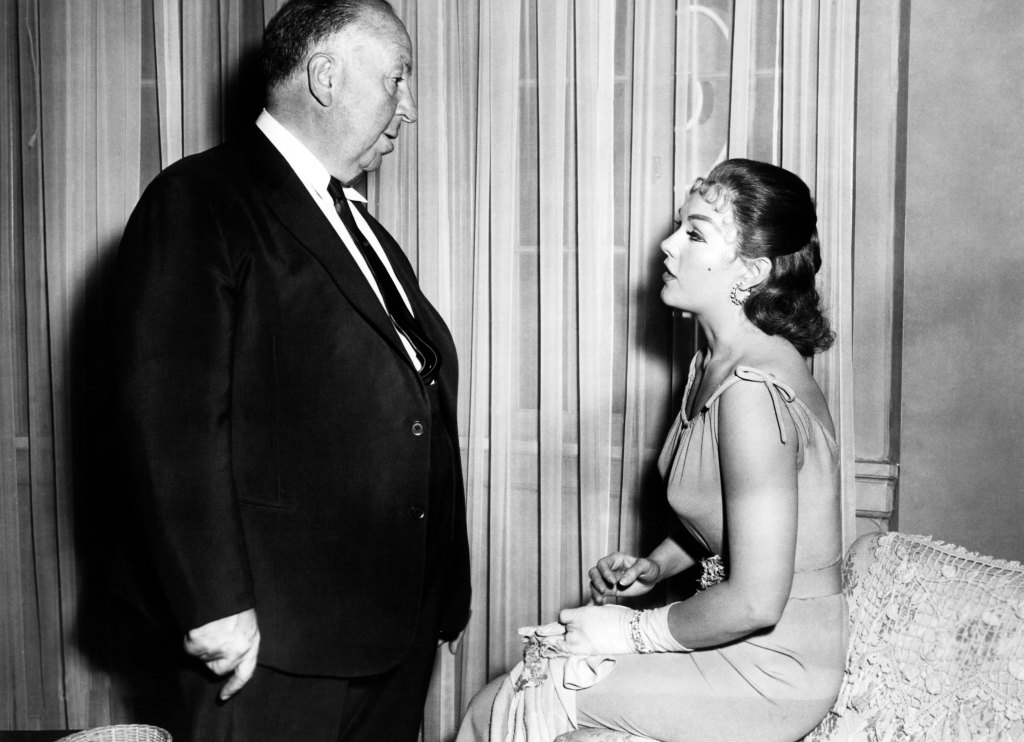 VERTIGO, Director Alfred Hitchcock discusses scene with Kim Novak on set, 1958