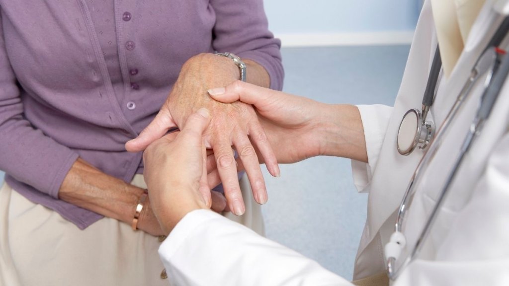 general practitioner examining patient and hand