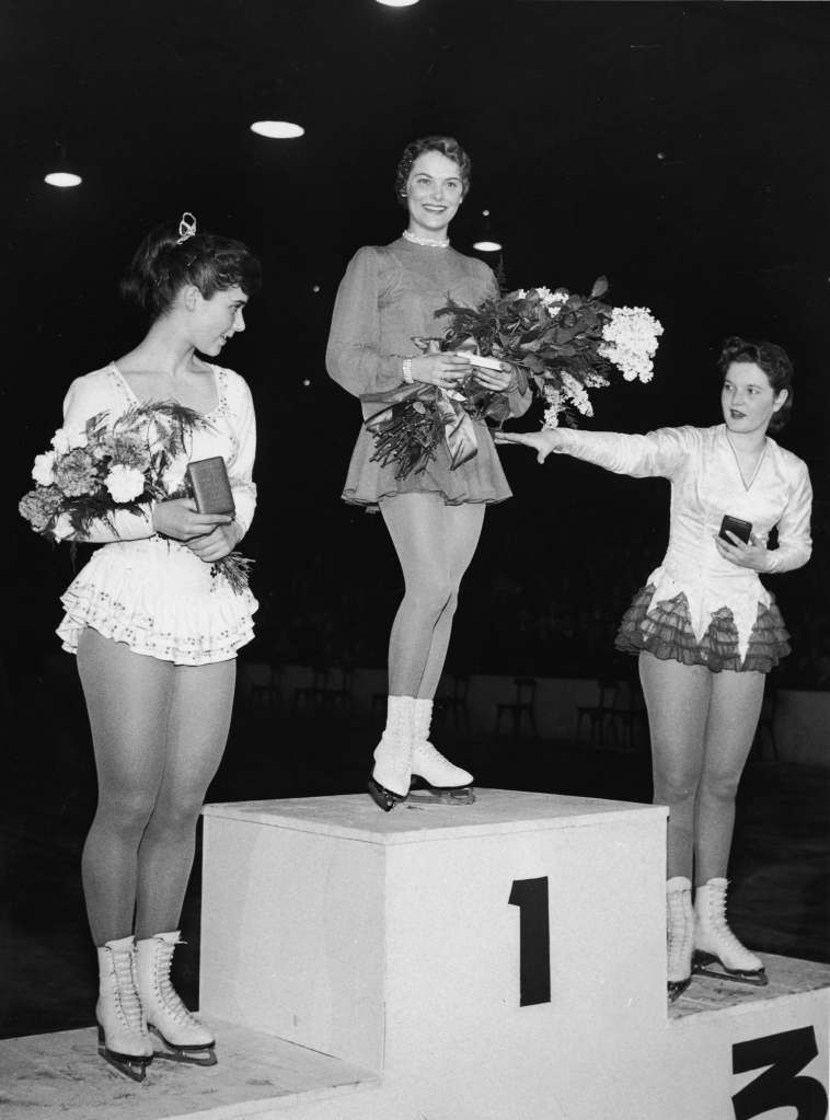 Carol Heiss (center) celebrates her gold medal with silver medalist Ingrid Wendl (left) and bronze medalist Hanna Walter (right), both from Austria