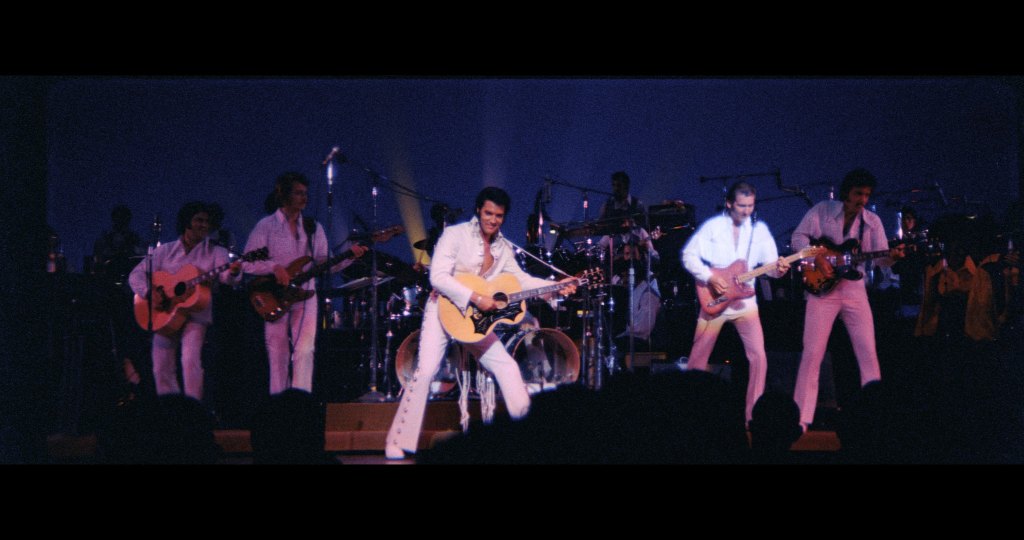 Elvis performs while wearing one of his signature jumpsuits in EPiC: Elvis Presley in Concert