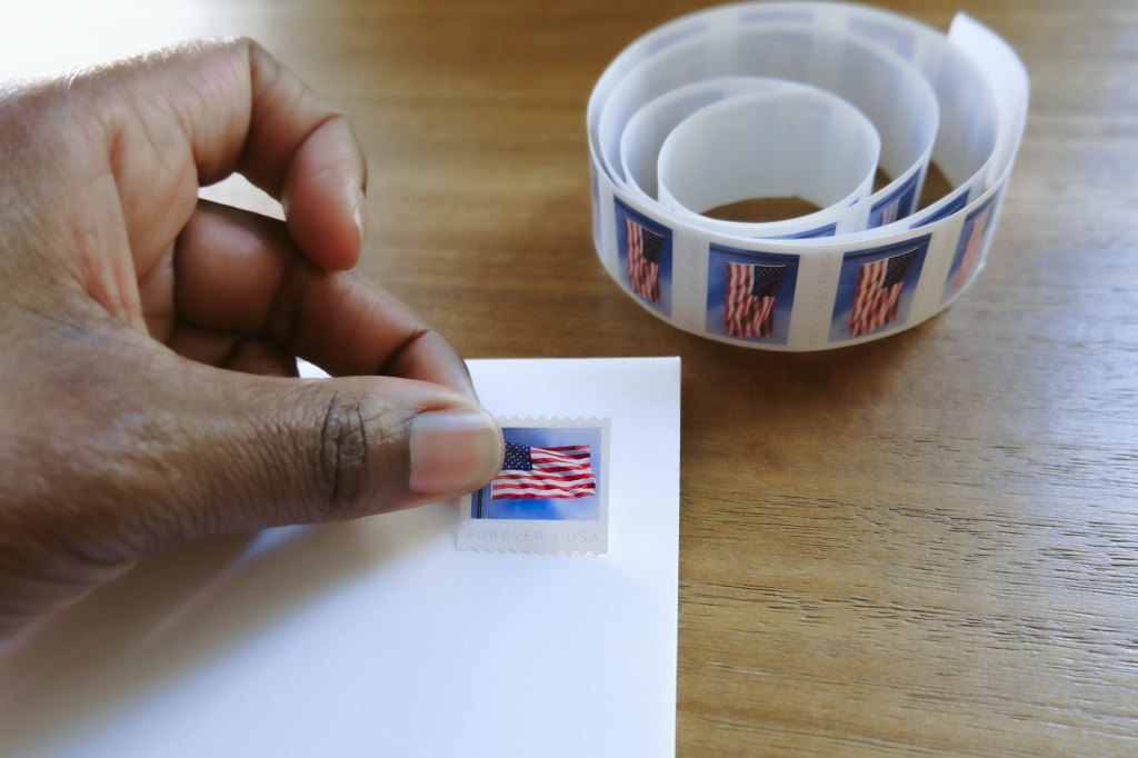 placing stamp on envelope