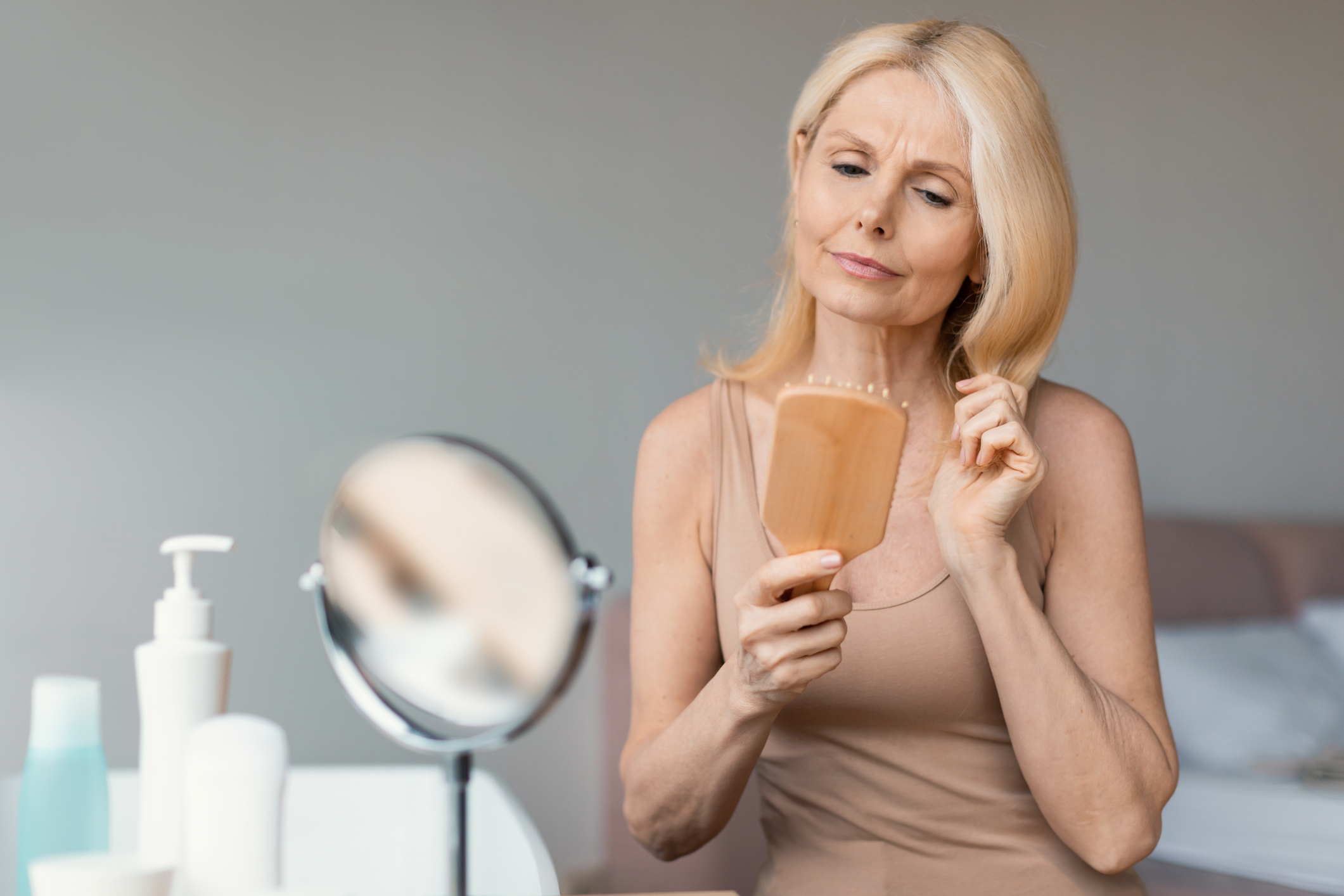 Woman brushing her hair looking concerned