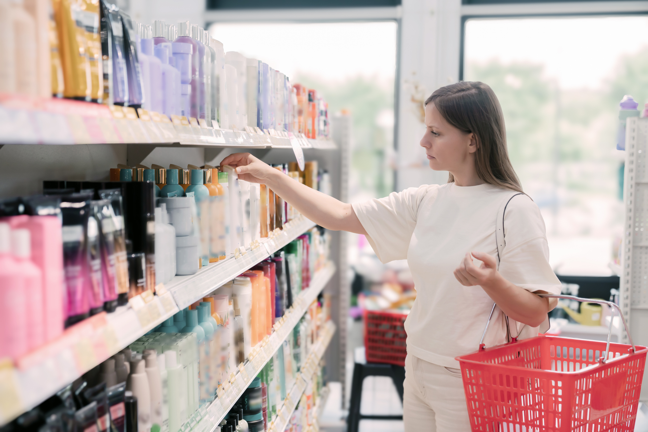A woman comparing shampoos during a shopping trip