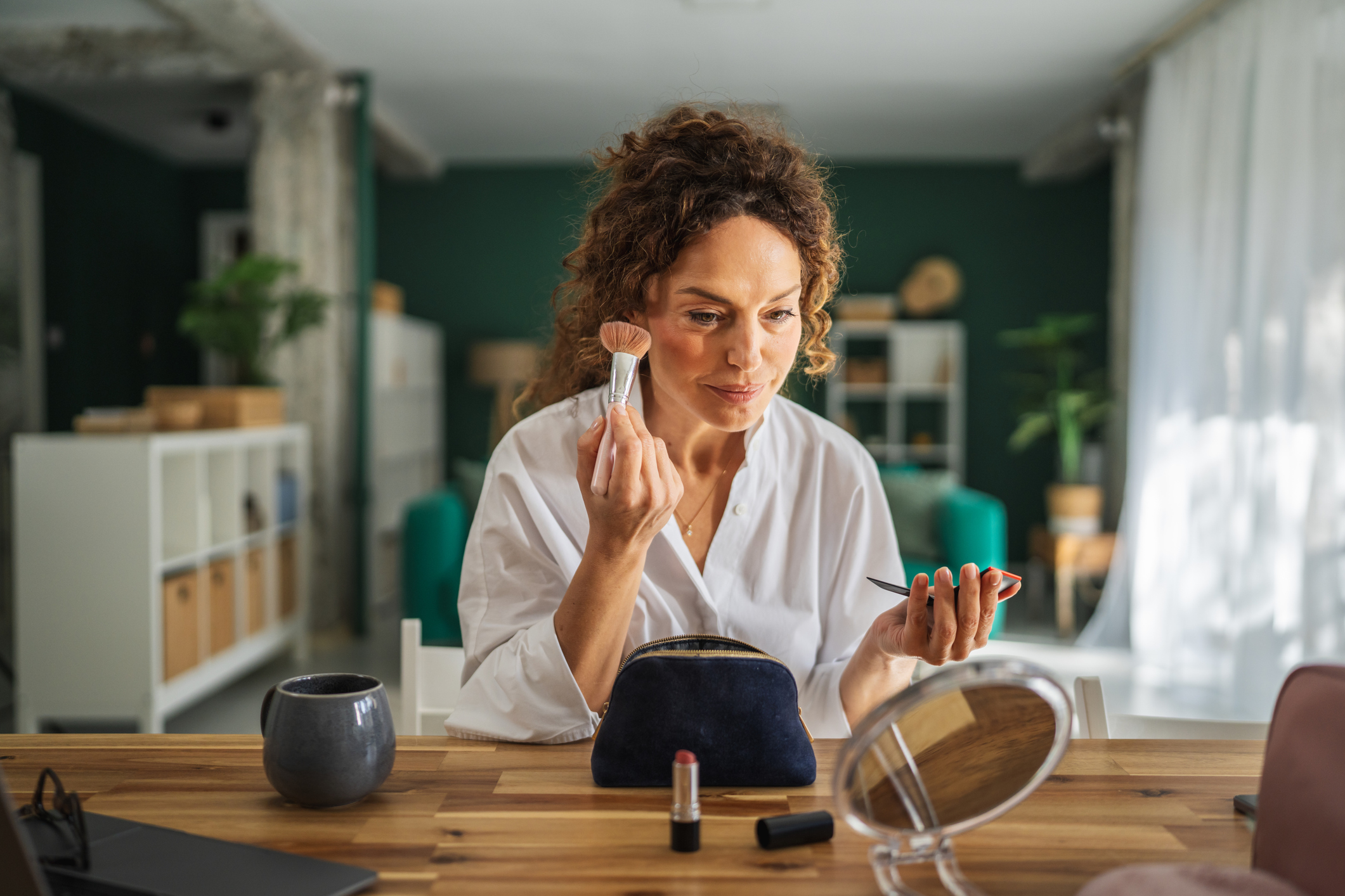 Adult woman applying makeup during morning self-care routine