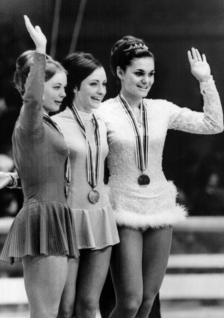 Peggy Fleming (center) celebrates her gold medal with bronze medalist Hana Mašková, from Czechoslovakia (left), and silver medalist Gabrielle Seyfert, from Germany (right)