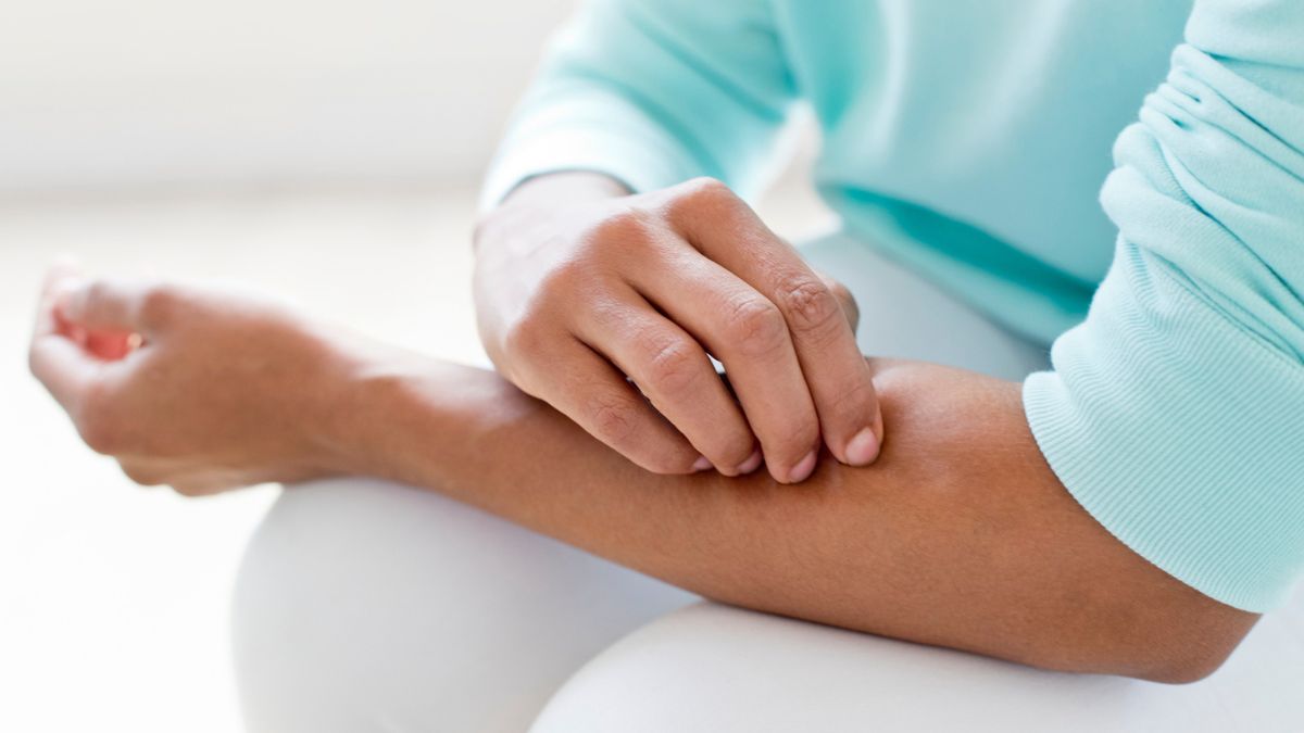 Woman feeling a lump under the skin on her forearm