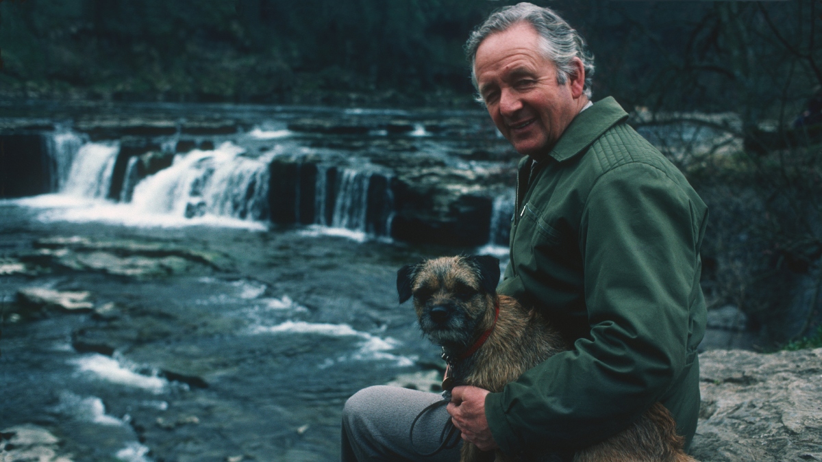 Dr. James Alfred Wight posing with his dog, 1982