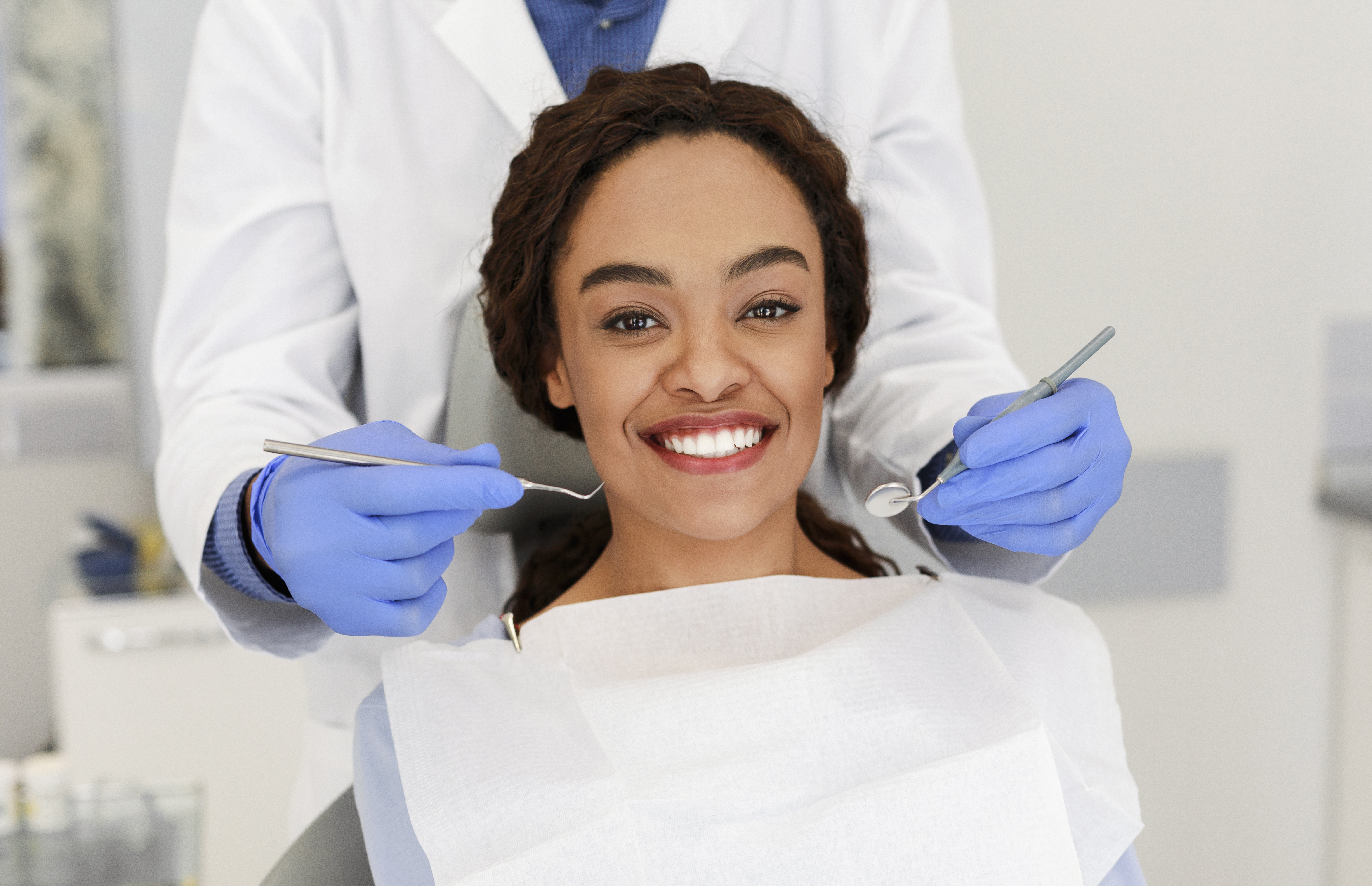 A smiling woman at the dentist after learning insider tips