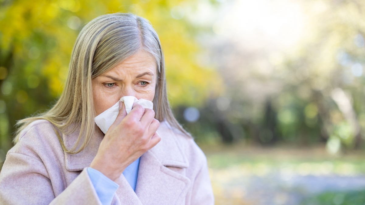 A woman blowing her nose due to nasal polyps congestion