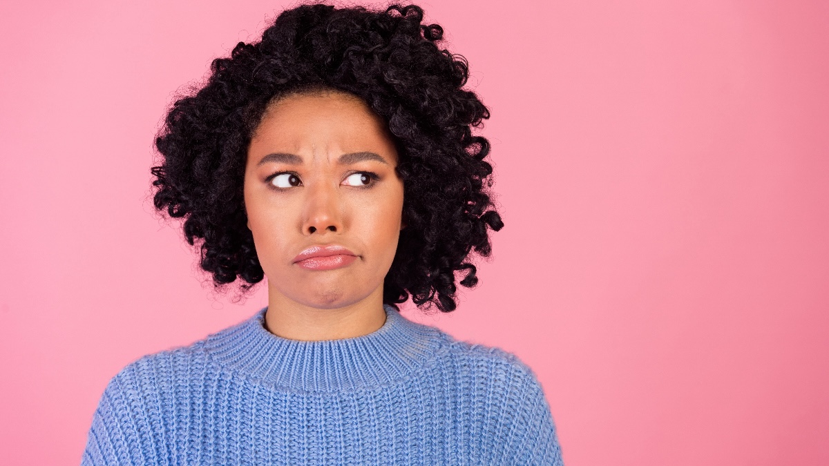 Woman looking to the side and pursing her lips because of a weird taste in her mouth