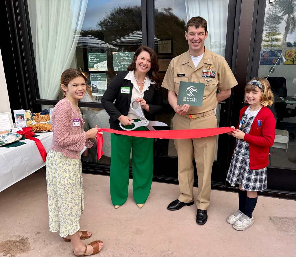 Crystal and her family at the ribbon cutting for Strength in Service