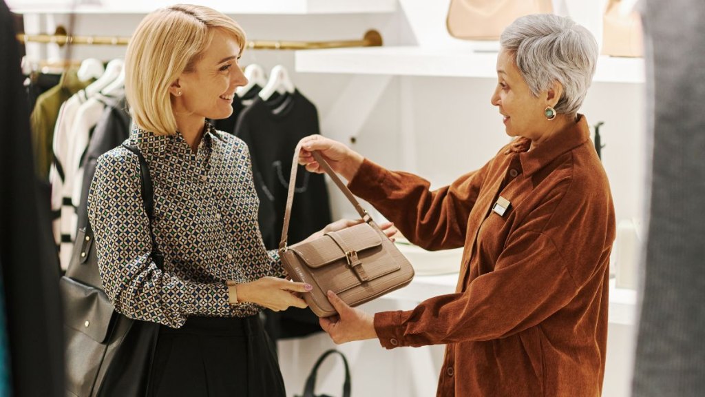 Adult mother and daughter enjoying shopping together and choosing bags boutique