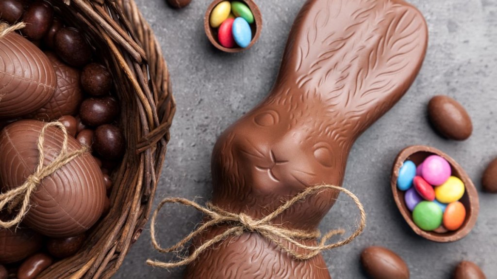 Chocolate Easter bunny and eggs on wooden background