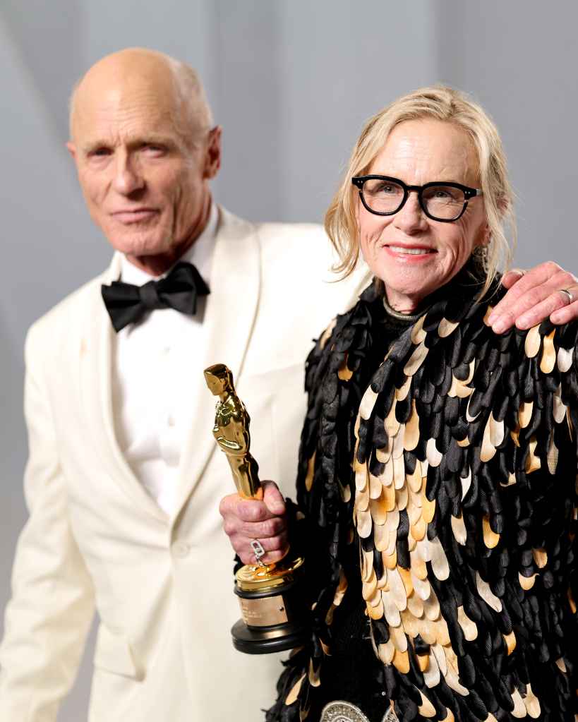 Amy Madigan shows off her award at the Vanity Fair Oscar Party with Ed Harris