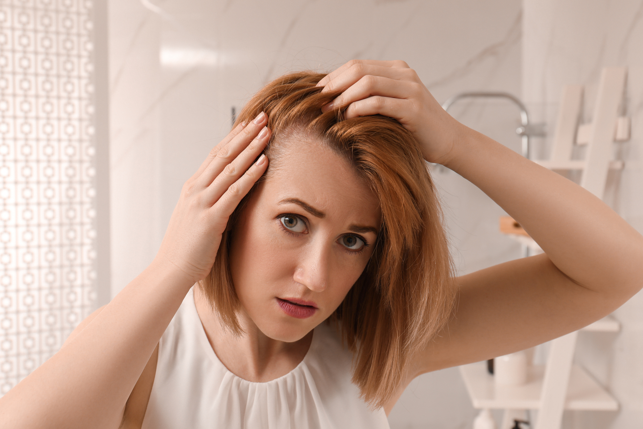 Woman checking her scalp in the mirror