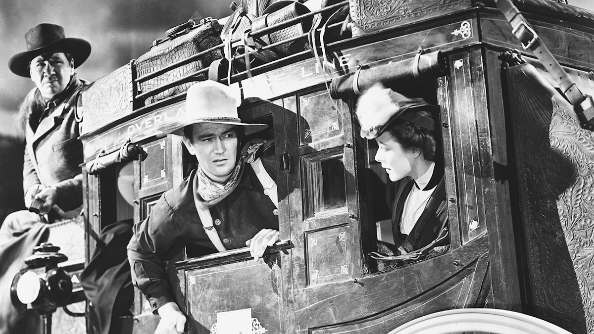 George Bancroft, John Wayne and Louise Platt) riding a horse-drawn carriage in a publicity still issued for the film, 'Stagecoach', 1939.
