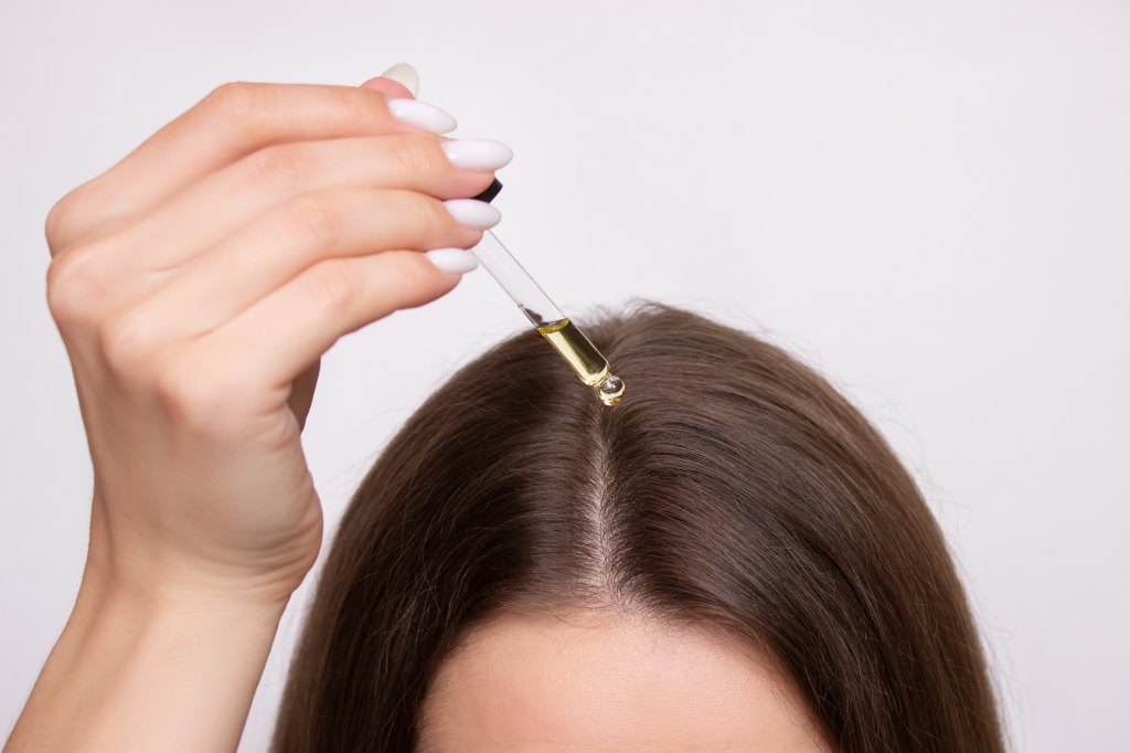 woman applying hair oil