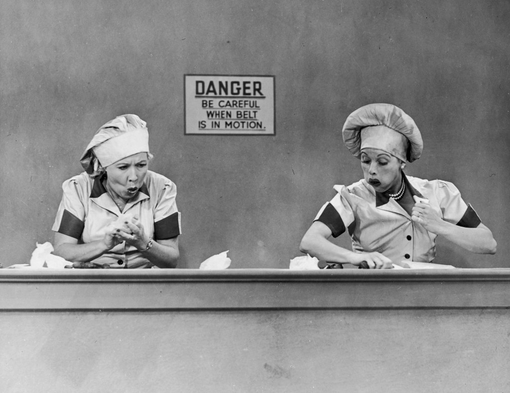 Vivian Vance (1909 - 1979), as Ethel Mertz, and Lucille Ball (1911 - 1989), as Lucy Ricardo, work side-by side at a candy factory conveyor belt in an episode of the television comedy 'I Love Lucy' entitled 'Job Switching,' Los Angeles, California, May 30, 1952. 