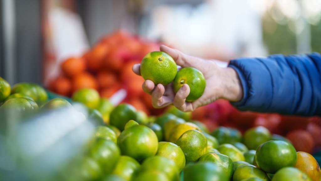 Senior woman buying tangerines at the greengrocer