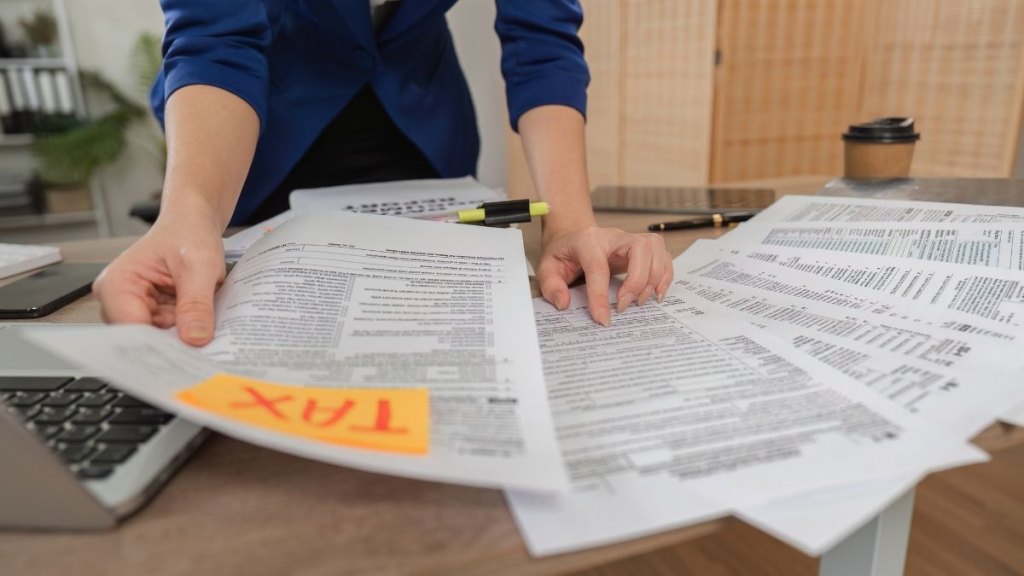 Woman sorting tax documents in a modern office environment