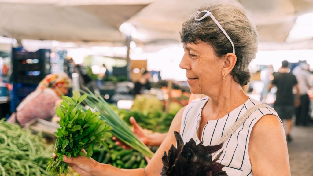 A woman at the market buying greens​