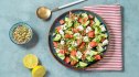 A bowl of veggies with a dish of nuts, all part of the Mediterranean diet