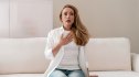 Woman placing her hand on her chest due to heart palpitations during menopause