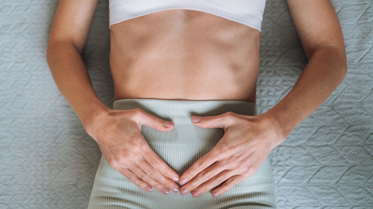 Close-up of a woman doing Kegel exercises with her hands on her lower abdomen