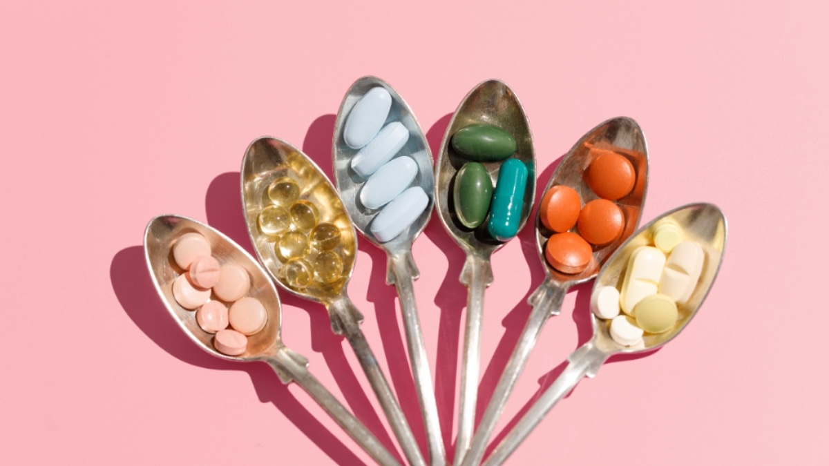 An assemblage of various arthritis supplements in vibrant hues arranged in spoons