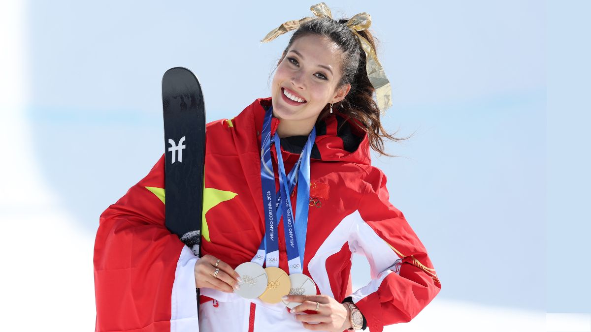 Olympic freestyle skier Eileen Gu, who practices a version of metacognition, poses with three medals around her neck