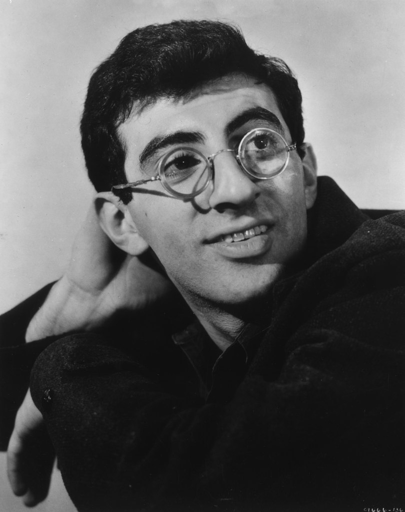 1955: Promotional headshot portrait of American actor Jamie Farr wearing round wire-rimmed glasses, for director Richard Brooks's film, 'Blackboard Jungle'. 