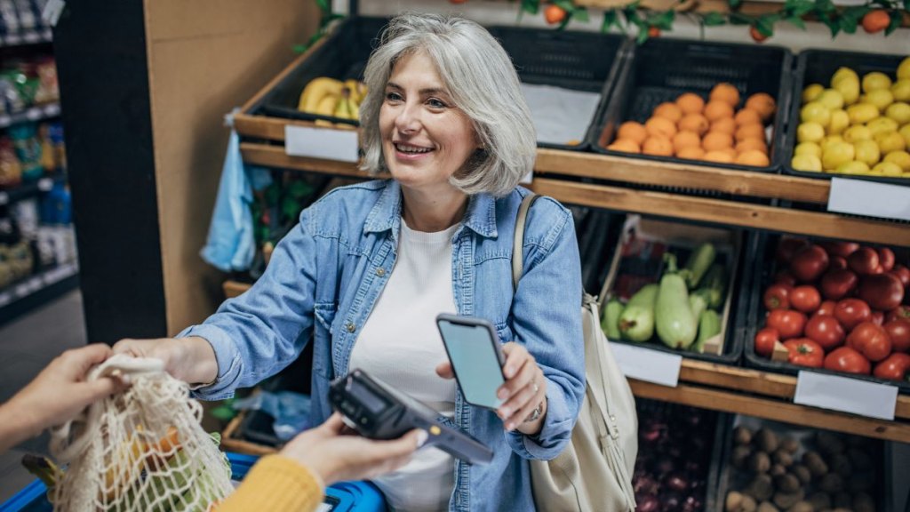 Mature woman buying groceries and fruit