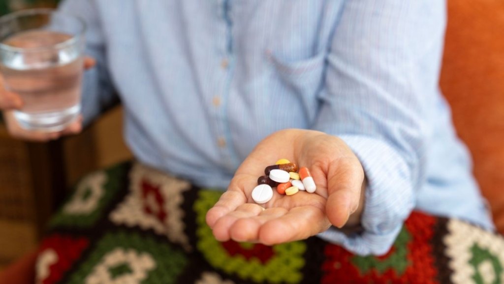 Senior woman hand holding a bunch of pills in an open palm