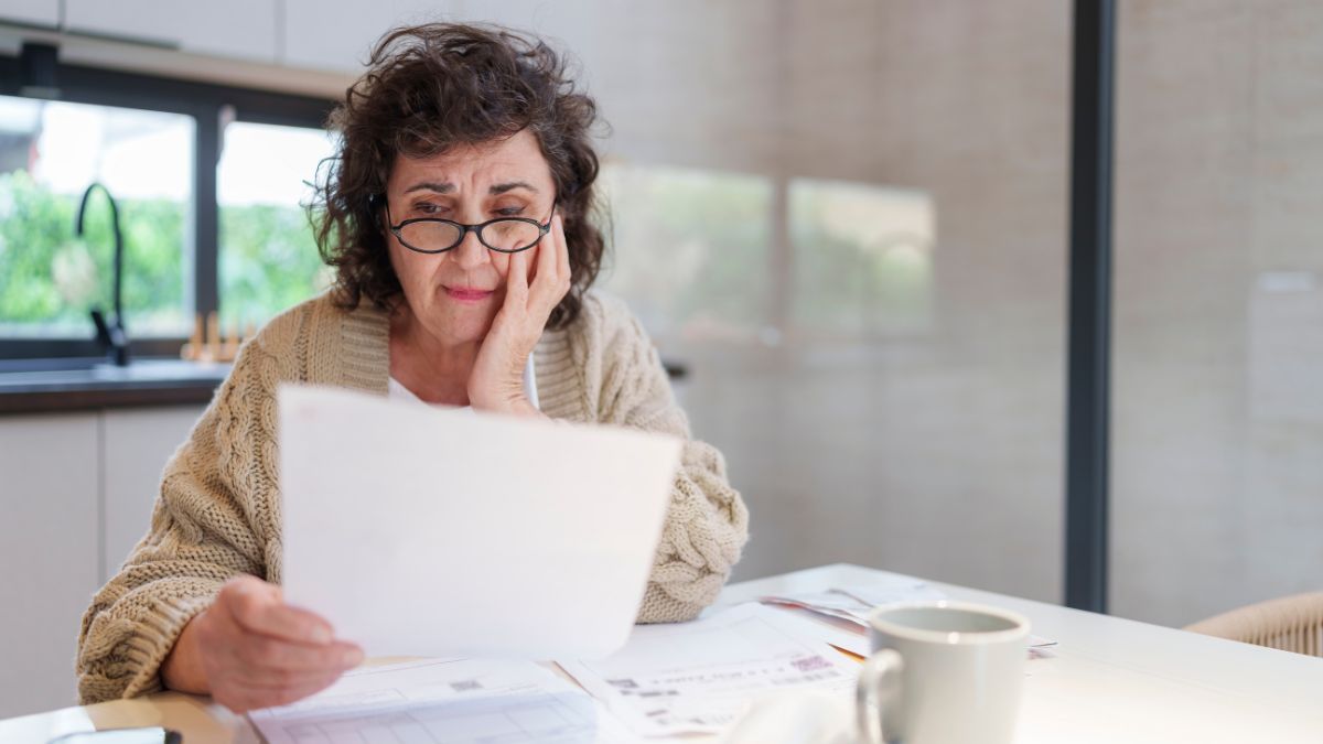 Stressed and Worried Senior Woman Calculating Domestic Expenses