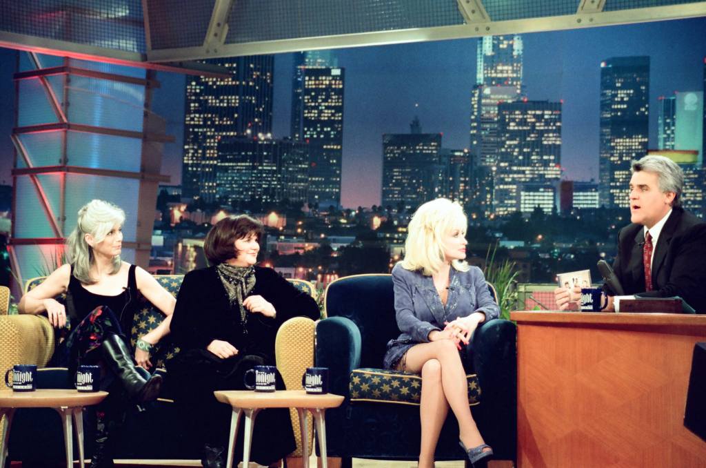 THE TONIGHT SHOW WITH JAY LENO -- Episode 1542 -- Pictured: (l-r) Musicians Emmylou Harris, Linda Ronstadt, Dolly Parton, host Jay Leno during an interview on February 9, 1999 -- (Photo by: Margaret Norton/NBCU Photo Bank/NBCUniversal via Getty Images via Getty Images)