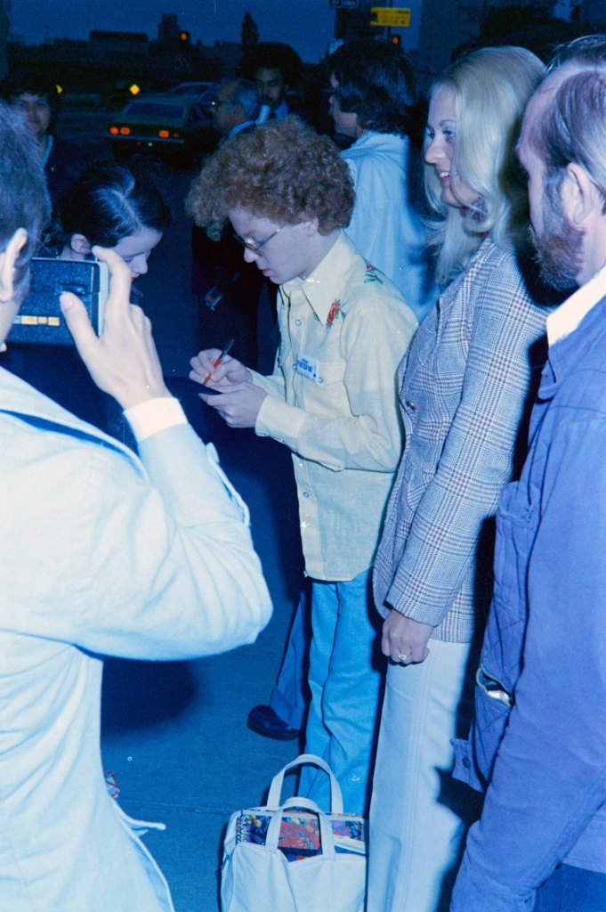 Johnny Whitaker (C) signs autographs during a rehearsal for the 46th Academy Awards in April 1974. 