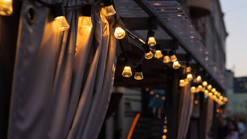 Lights of a beautiful light garland of a cafe patio on a city street